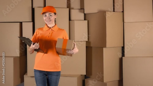 Female courier in orange uniform delivering a parcel to wrong address. Mistake or inaccuracy concept, 4K shot photo