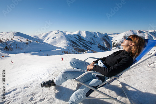 femme bronzant un transat dans la neige