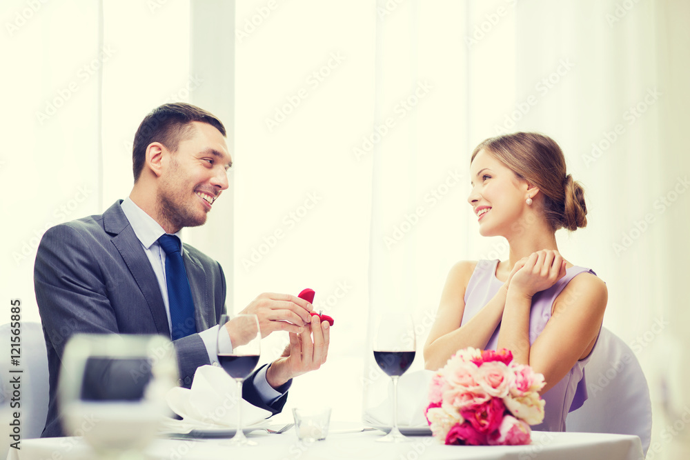 man proposing to his girlfriend at restaurant