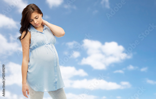 pregnant woman with neckache over blue sky © Syda Productions