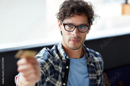 happy man paying with credit card at cafe