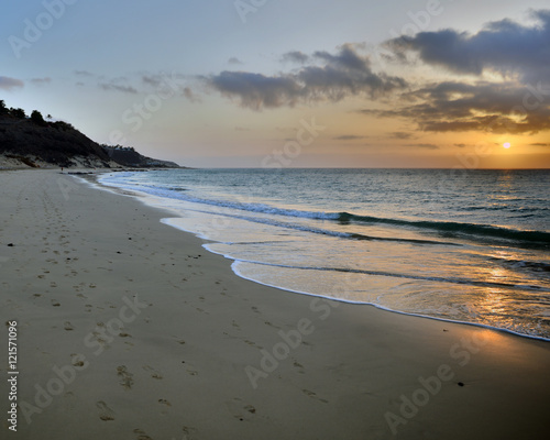 Foot prints in the sand at sunrise