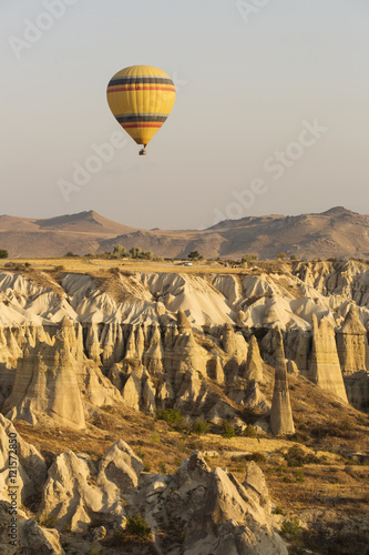 Hot air balloon flying over rock landscape at Cappadocia Turkey