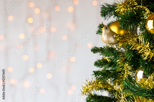 Gold glitter robin on Christmas tree. Copy space.