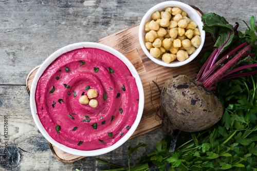 Beet hummus and chickpeas on wooden table

