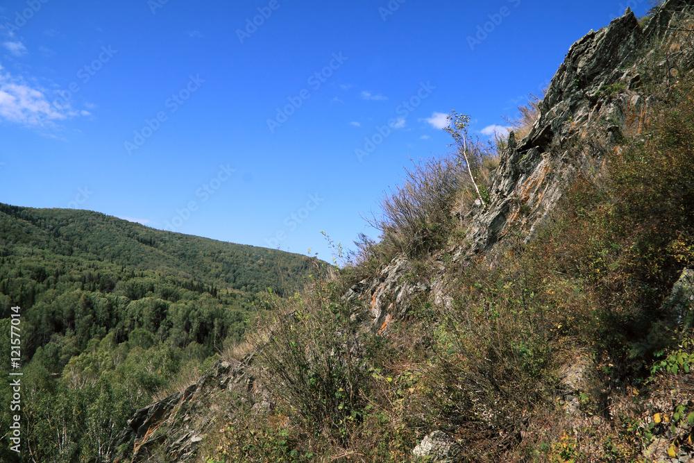 Obraz premium Abrupt stony slope on a background of the blue sky