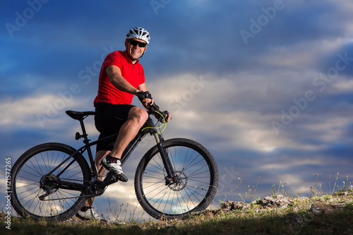 Man in helmet and glasses stay on the bicycle