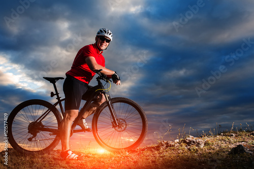 Man in helmet and glasses stay on the bicycle