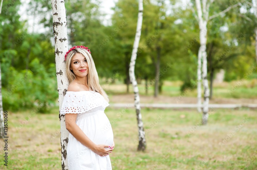 Beautiful lovely girl wearing her first child in the stomach and is looking forward to his birth. Strolling in the park, enjoy nature and quietness Beautiful lovely girl wearing her first child in the stomach and is looking forward to his birth. Strolling in the park, enjoy nature and quietness