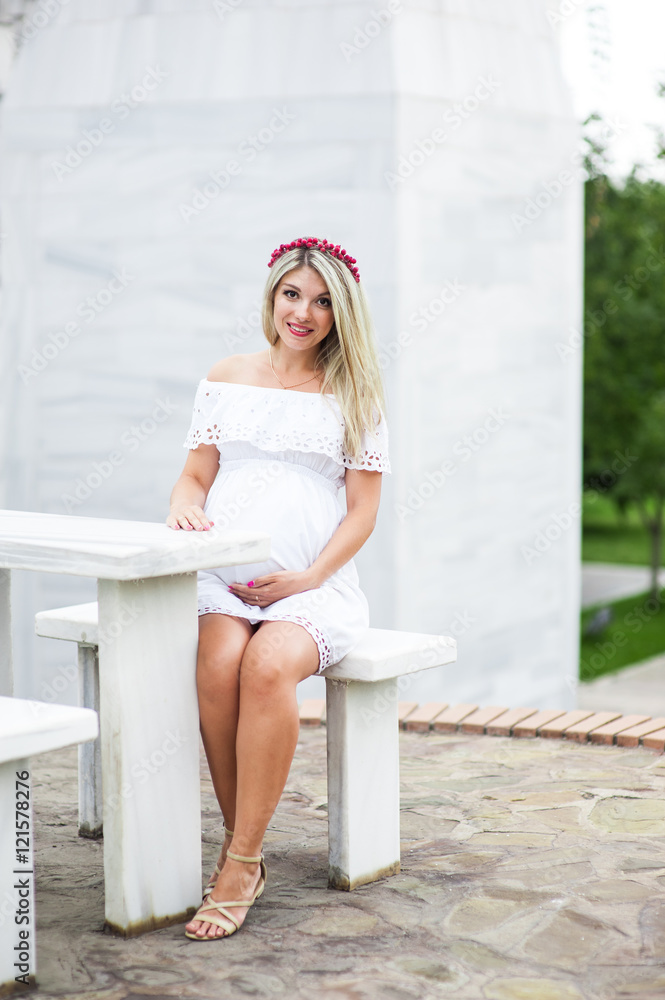Beautiful lovely girl wearing her first child in the stomach and is looking forward to his birth. Strolling in the park, enjoy nature and quietness Beautiful lovely girl wearing her first child in the stomach and is looking forward to his birth. Strolling in the park, enjoy nature and quietness