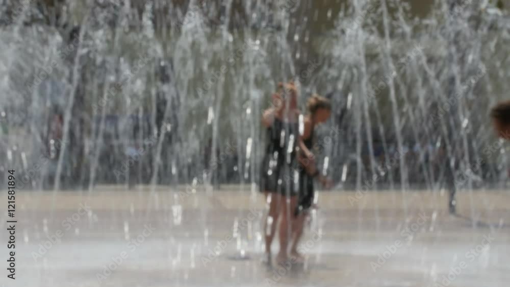 girls running and dancing through the fountain, images is blurred, no recognizable people girls running and dancing through the fountain, images is blurred, no recognizable people