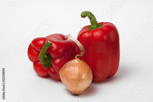Two red bell peppers and an onion