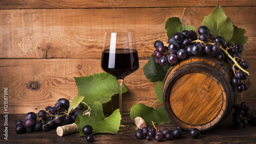 Tela calice di vino rosso con uva e botte