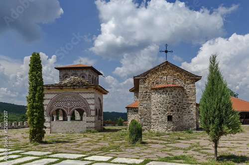 View of inner yard with old medieval church, alcove and bell tower in restored Montenegrin or Giginski monastery St. St. Cosmas and Damian, mountain Kitka, Breznik, Pernik region, Bulgaria 
