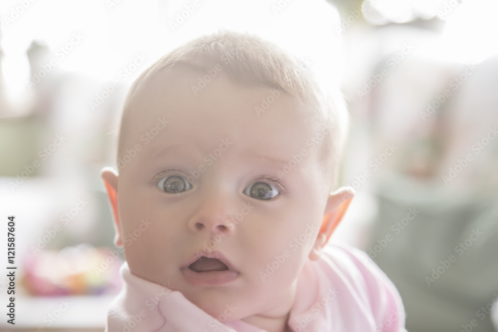Surprised toddler looking round in soft light Surprised toddler looking round in soft light