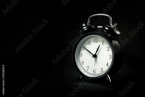 black retro alarm clock in dark background.