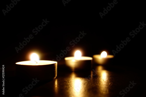 Candles burning. Dark background.