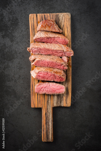Sous vide cooked and seared fillet steak on rustic wooden board