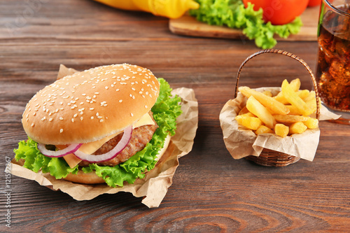 Hamburger with fries on wooden background