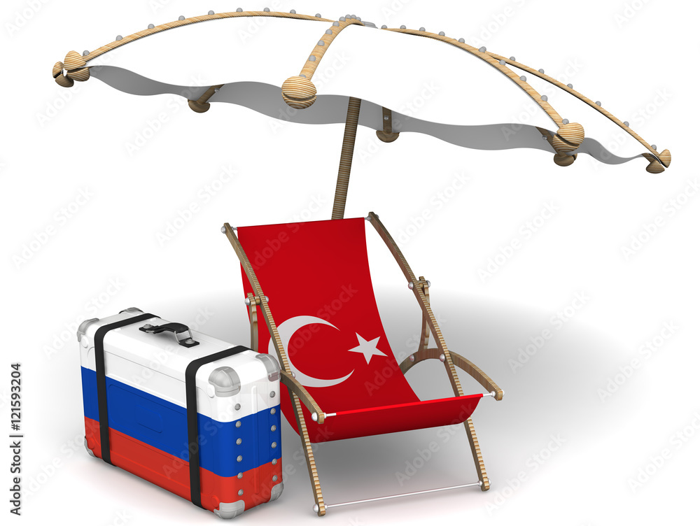 Russian tourists in Turkey. Sunbed with a flag of Turkey, a suitcase with the flag of the Russian Federation and a beach umbrella on the white surface