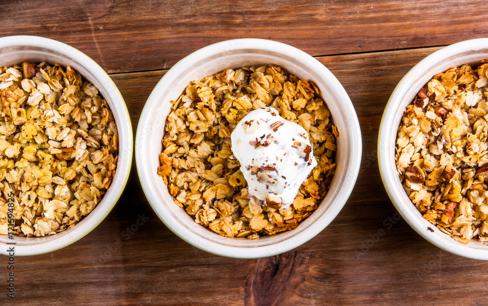 Three portion of freshly made autumn apple crumble with fresh green apples on a wooden table, top view Three portion of freshly made autumn apple crumble with fresh green apples on a wooden table, top view