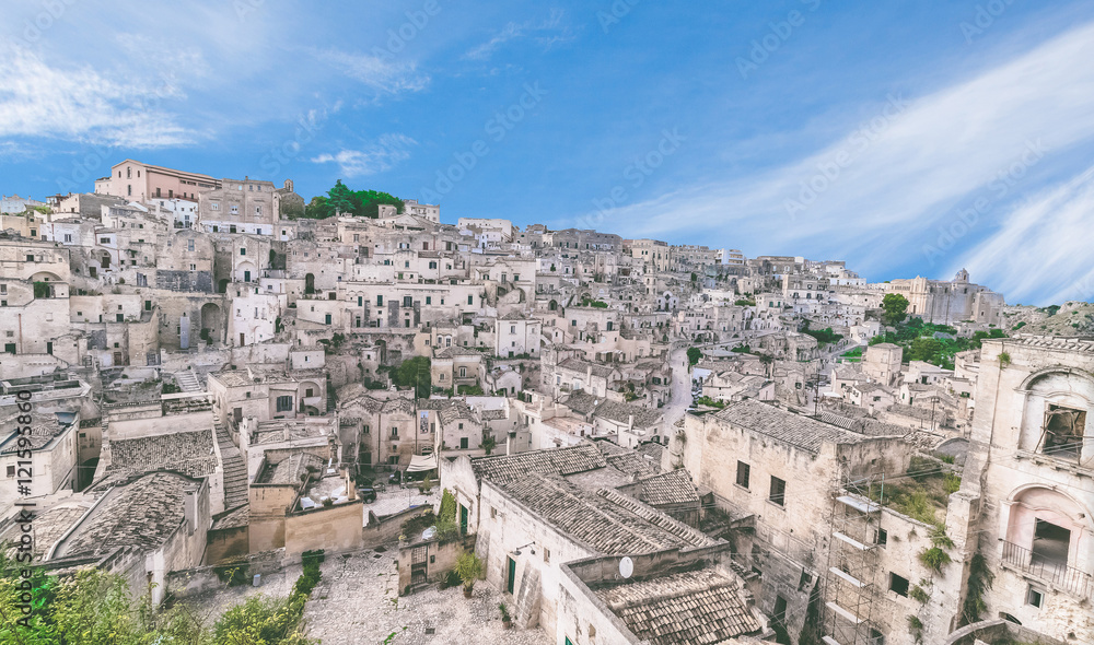 panoramic view of typical stones (Sassi di Matera) and church of Matera under blue sky