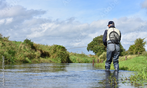 Back view of fly-fisherman fishing in river