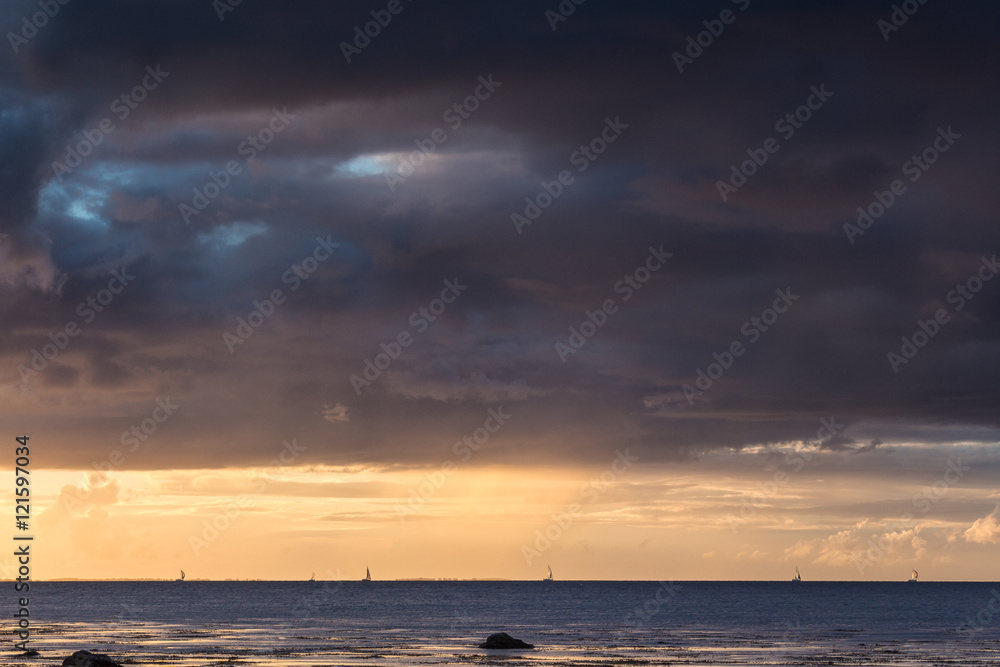 Sailing under dark skies along the Wild Atlantic Way in Tralee Bay, County Kerry, Ireland