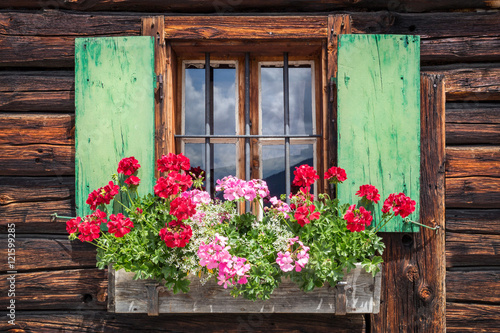 Window of an old wooden cabin in the alps