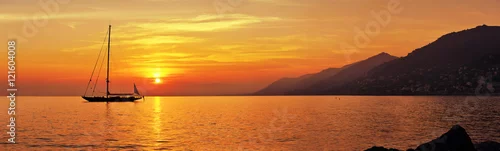 Obraz  z motywem Panoramic view of Sailing at sunset with mountains