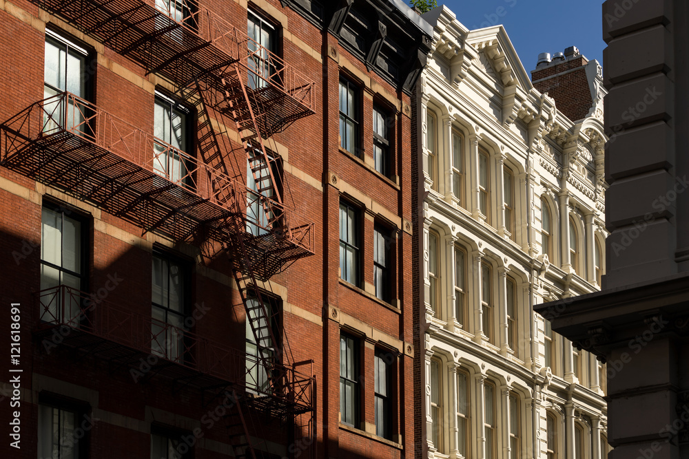 Soho buildings with brick and cast iron facades and fire escape. Manhattan, New York City