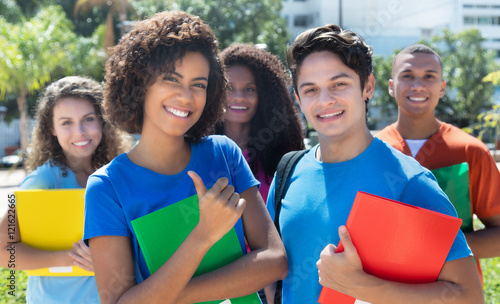 Gut gelauntes Studentpaar mit internationalen Freundinnen photo