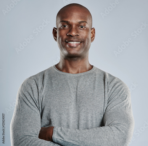 Confident black man with pleasant smile in gray photo