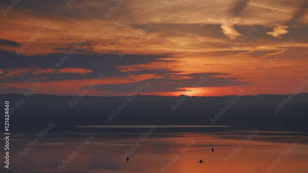 Rich orange sunrise on the river. Fast moving clouds, the sun rises. Rich orange sunrise on the river. Fast moving clouds, the sun rises.