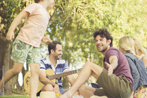 Man at picnic watching children play photo