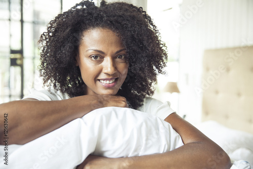 Woman holding pillow, portrait photo