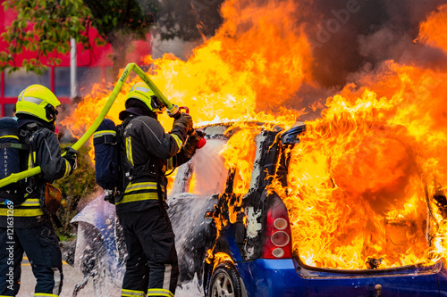 burning car with firefighters