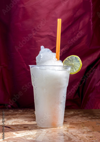 Lemon juice frappe tastes fruit sweet and sour in glass on background purple curtain luxurious photo