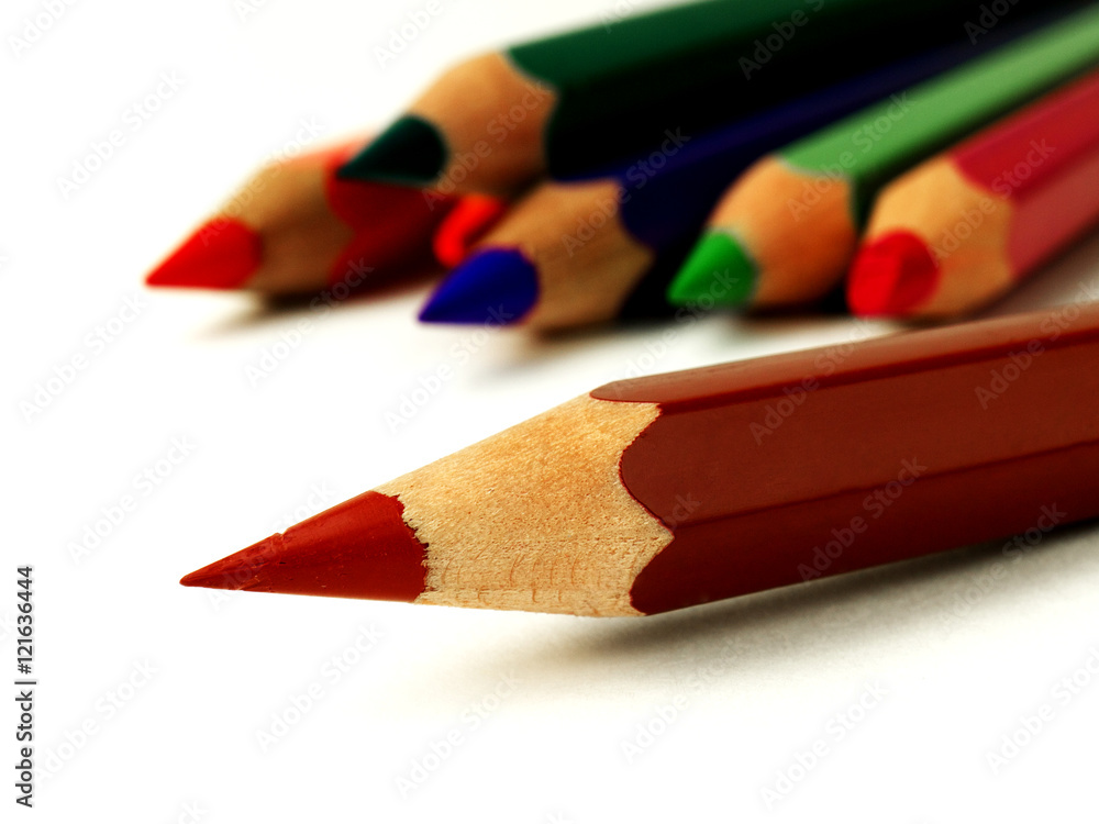Obraz premium brown colored pencil in front of other pencils on white background, macro, shallow depth of field