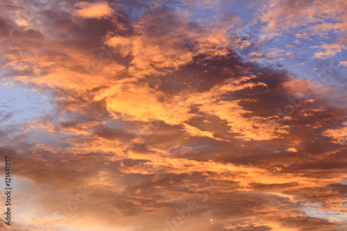 Fiery sunset with orange cloud and blue sky