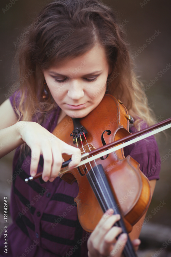 Young woman playing the violin at pier forest lake park. Shallow depth of field. Musical notes near girl. Young woman playing the violin at pier forest lake park. Shallow depth of field. Musical notes near girl.