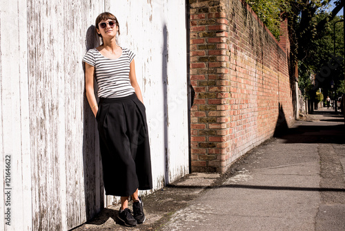 Hipster woman wearing sunglasses dressed in urban minimal style