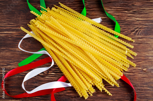 Uncooked Authenric Tripoline spaghetti pasta with italian flag style ribbons photo