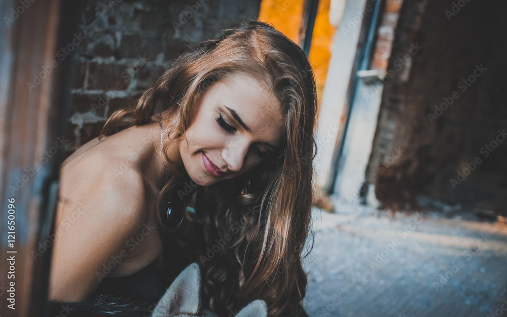 young pretty women with long lush curly blonde hair and thoughtful face in green dress standing near stony wall and big window sunny day young pretty women with long lush curly blonde hair and thoughtful face in green dress standing near stony wall and big window sunny day