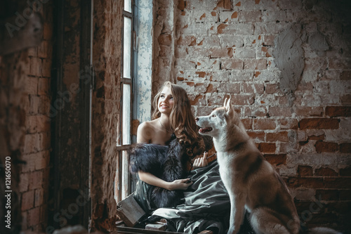 Wooman with dog husky, huskies near old window in collapsed old house and brick wall. Farytale.
