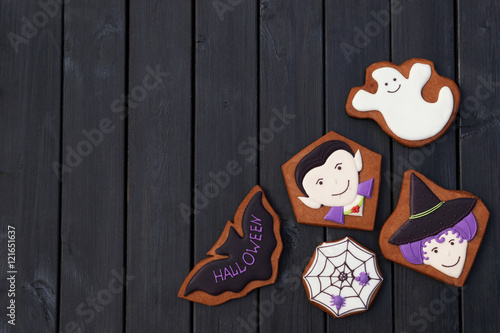 Funny halloween homemade gingerbread cookies on black wooden background. Free place for text. © greenoline