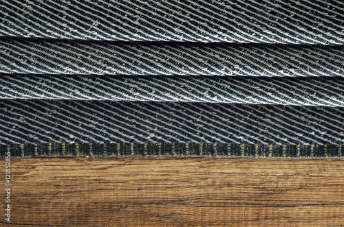 Dark gray cloth folded in a pile on a wooden surface photo