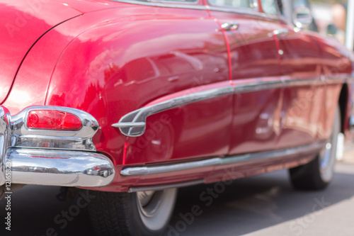 Red retro car. The view from the side. Chrome lining. An American classic.
