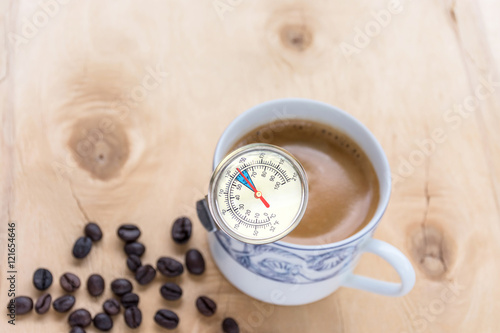 Use a thermometer measures the temperature of the coffee in the coffee cup.
