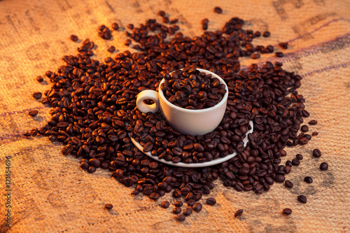 Coffee cup surrounded by coffee beans